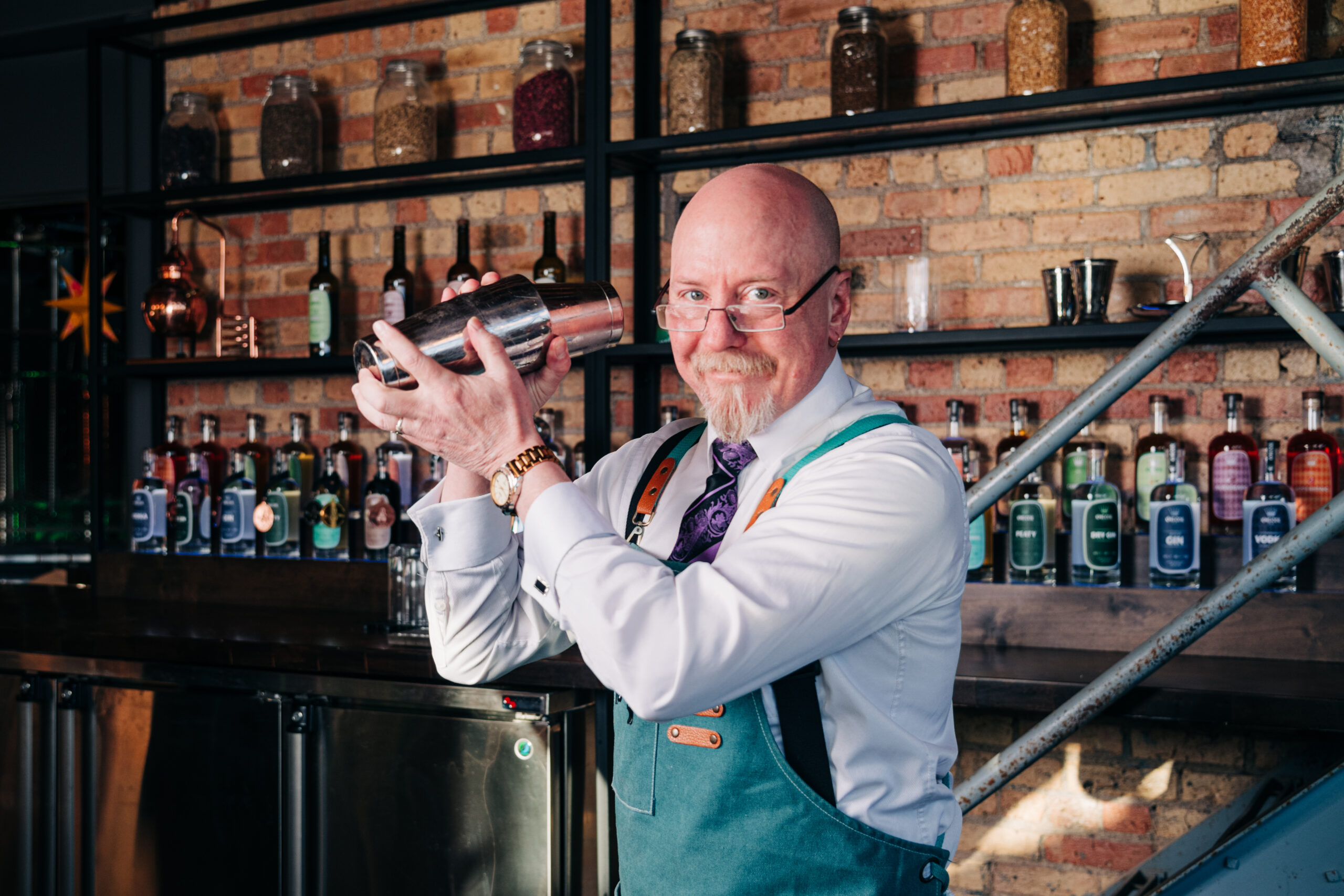Man sitting at King Coil Spirits bar holding a cocktail during a branding photoshoot.